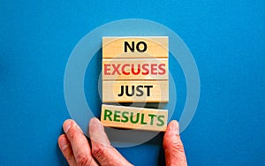 No excuses just results symbol. Concept words No excuses just results on wooden blocks. Businessman hand. Beautiful blue table