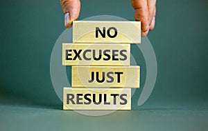 No excuses just results symbol. Concept words No excuses just results on wooden blocks. Businessman hand. Beautiful grey table