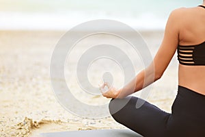 No face portrait of young woman doing yoga or meditating on the seaside.