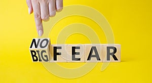 No fear vs big fear symbol. Businessman points at turned wooden cubes withs words Big fear and No Fear. Beautiful yellow