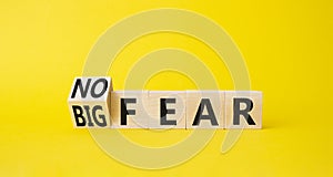 No fear vs big fear symbol. Turned wooden cubes withs words Big fear and No Fear. Beautiful yellow background. Business concept.