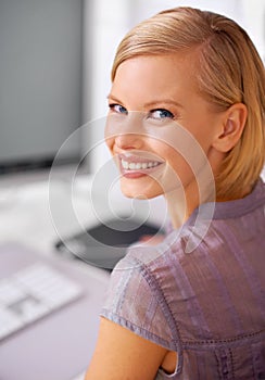 No first day jitters here. Portrait of a beautiful young woman sitting at her desk in an office.