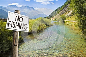 No fishing area - concept with information on road sign against a stream of water