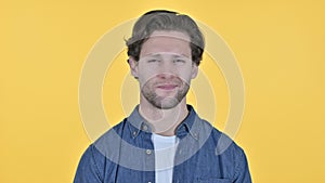 No gesture by young man, head shake on yellow background