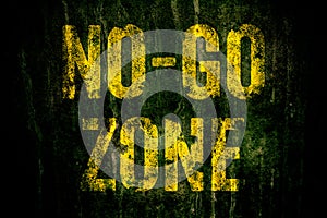 â€œNo-Go Zoneâ€ warning sign in yellow letters painted over dark grungy concrete wall with moss