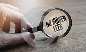 No hidden fees text under magnufying glass. Fees and taxes business concept