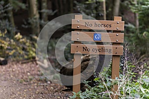 A no horses and no cycling signpost at the entrance of Chantry Woods on the North Downs Way near Guildford, Surrey