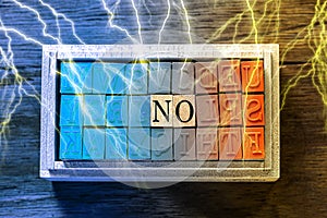 NO - isolated abstract in blue and orange wood type stamps and lightning or thunder against wooden background and copy space