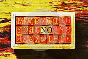 NO - isolated abstract in wood type stamps against wooden background and copy space