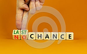 No or last chance symbol. Businessman turns wooden cubes and changes words `no chance` to `last chance`. Beautiful orange