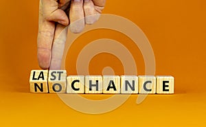 No or last chance symbol. Businessman turns wooden cubes and changes words `no chance` to `last chance`. Beautiful orange