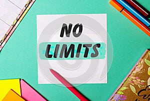 NO LIMITS written on a turquoise background near bright stickers, notepads and markers