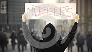 NO MURDERS text on a protest banner