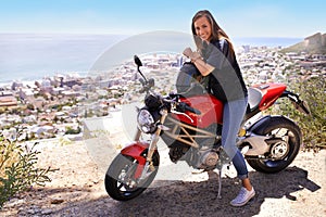 No one around but me and my bike. A beautiful young woman sitting on her red motorcycle.