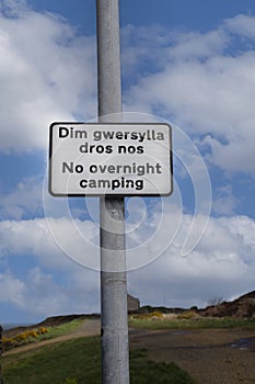 No overnight camping sign, in English and Welsh