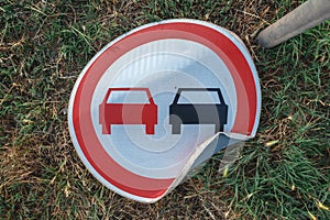 No overtaking traffic sign knocked on the ground photo
