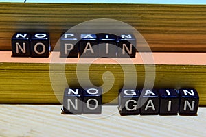 No pain no gain on wooden blocks. Education and business concept