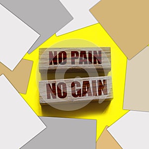 No Pain No Gain message written with wooden blocks on yellow. Business success concept