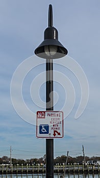 No Parking except for handicapped sign on a lamp post photo