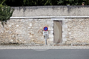 No parking sign against stone wall
