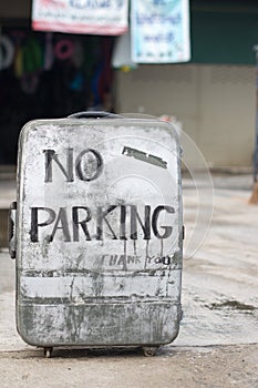 No parking sign on an old suitcase.