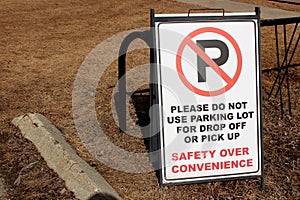 No Parking sign in a school staff lot beside some bike racks