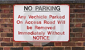 NO PARKING sign on very old brick wall - Tooting, London, UK