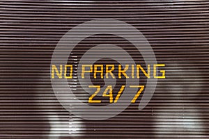 No parking 24, 7 text painted on garaje door photo