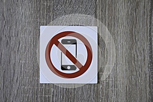 No phone allowed sign on the wooden wall