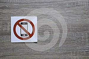No phone allowed sign on the wooden wall with space for adding text on the right photo