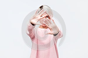 No pictures, please. Young celebrity is hiding face with a hand