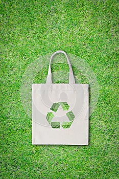 No plastic bag, shopping bag concept with fabric sack cloth totebag with recycle sign isolated on green lawn clipping path