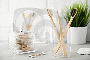 No plastic concept. Eco friendly bathroom accessories. Bamboo toothbrushes, cotton pads and cotton buds on a light gray