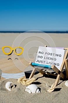 NO POSTING NO LIKING JUST LIVING text on paper greeting card on background of beach chair lounge starfish summer