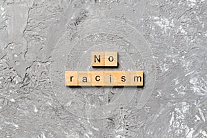No racism word written on wood block. No racism text on table, concept