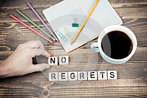 No Regrets. Wooden letters on the office desk