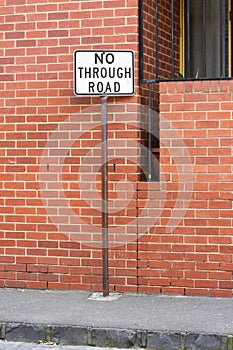 No through road sign in front of a brick wall.
