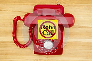 No Robo Call message on a sticky note on a red old retro rotary phone