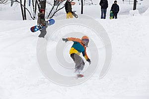 Kid jumping over a hill made of snow with snowboard