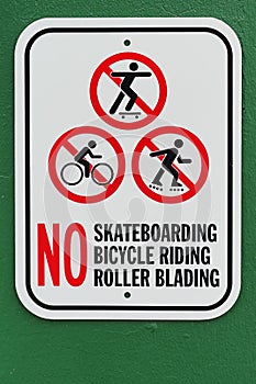 No skateboarding bicycle riding roller blading sign with green background