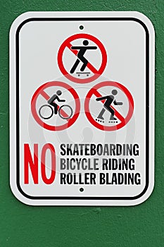 No skateboarding bicycle riding roller blading sign with green background photo