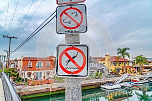 No skateboarding and no diving signs at a footbridge over canal in Long Beach CA