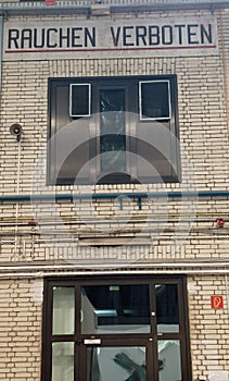 `no smoking` billboard on white brick wall