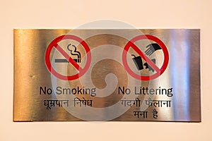 No Smoking and no littering signs on metal plate