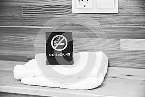 No smoking sign on the bedside table. Hotel towels