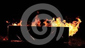 No sound. Close-up video of a burning picnic bench at the end of a party. Summer holidays fun or malicious destruction of property