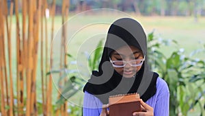 No sound Standing Indonesia Muslimah or Islam girl playing kalimba at yard