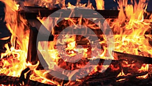 No sound. Thirty 30 seconds. Close-up of burning picnic bench at the end of a party.