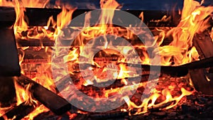 No sound. Twenty-five 25 seconds. Extreme close-up of burning picnic bench at the end of a party.