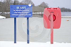 No swimming or paddling deep water danger sign and red buoy ring life save